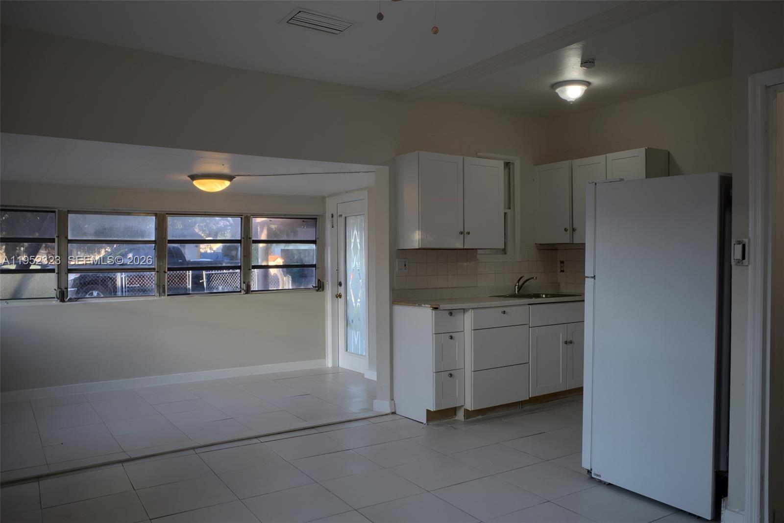 43 Southwest 11th Street, Unit W Dania Beach, FL 33004 - Photo 12 of 23 a kitchen with white cabinets and a refrigerator