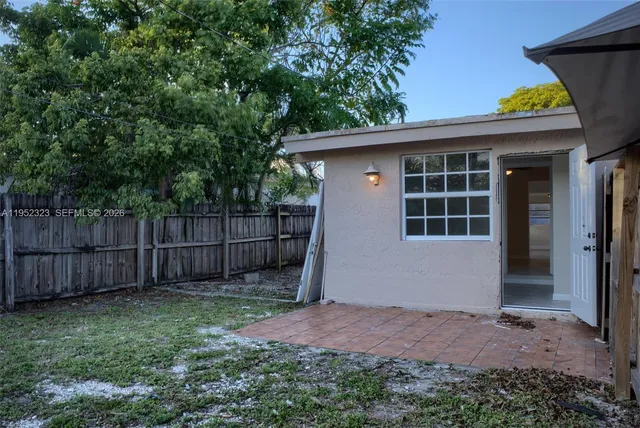 a view of a backyard with large trees and wooden fence