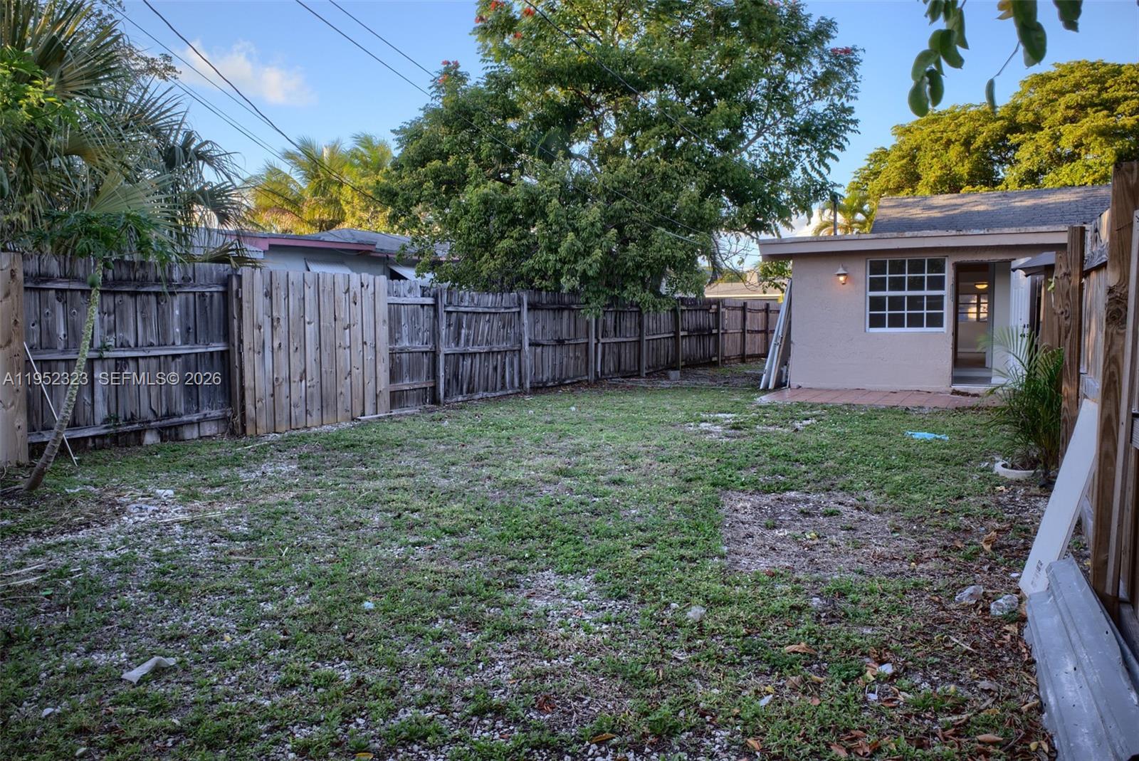 43 Southwest 11th Street, Unit W Dania Beach, FL 33004 - Photo 19 of 23 a view of a backyard with large trees and wooden fence