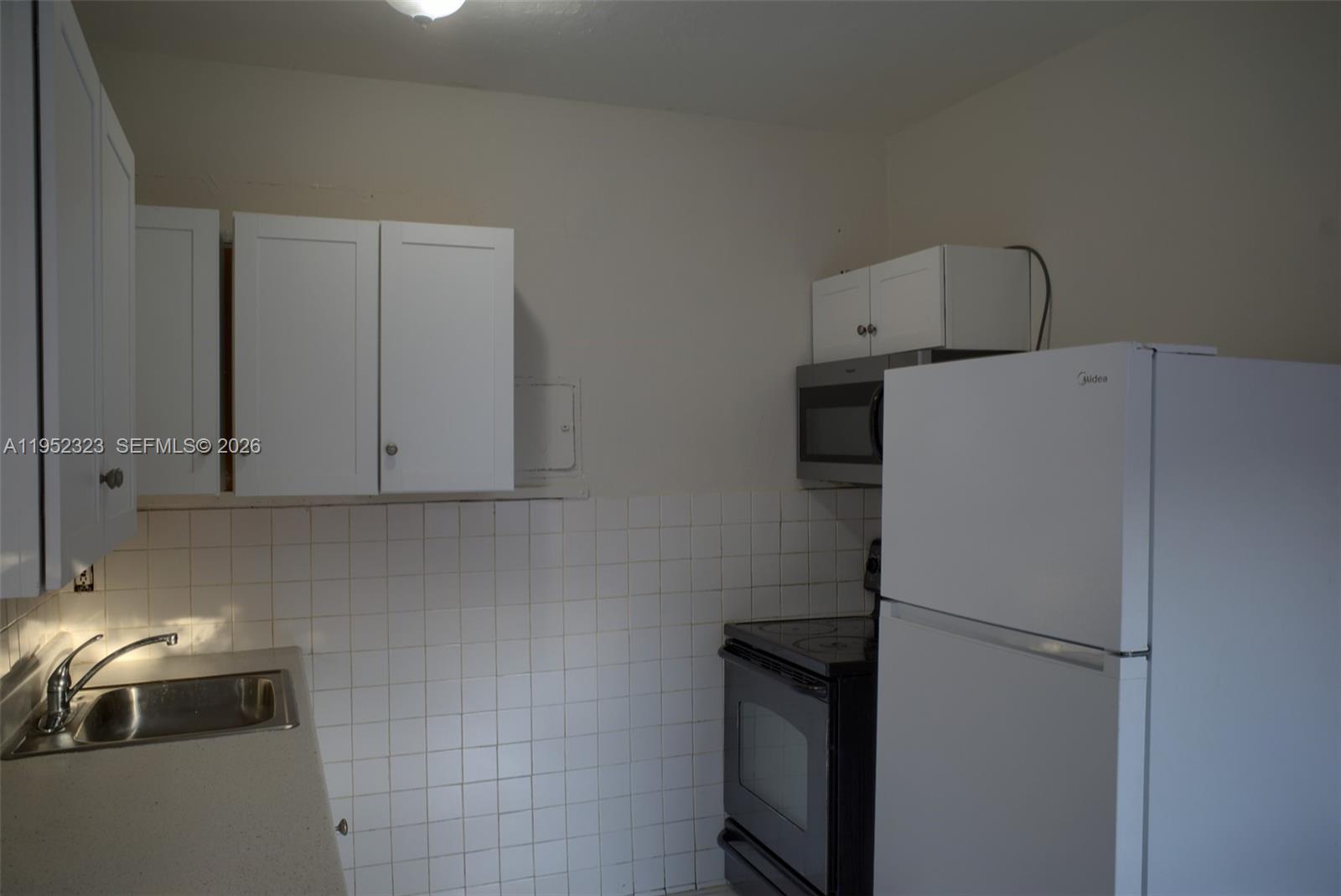 43 Southwest 11th Street, Unit W Dania Beach, FL 33004 - Photo 4 of 23 a white refrigerator freezer sitting in a kitchen