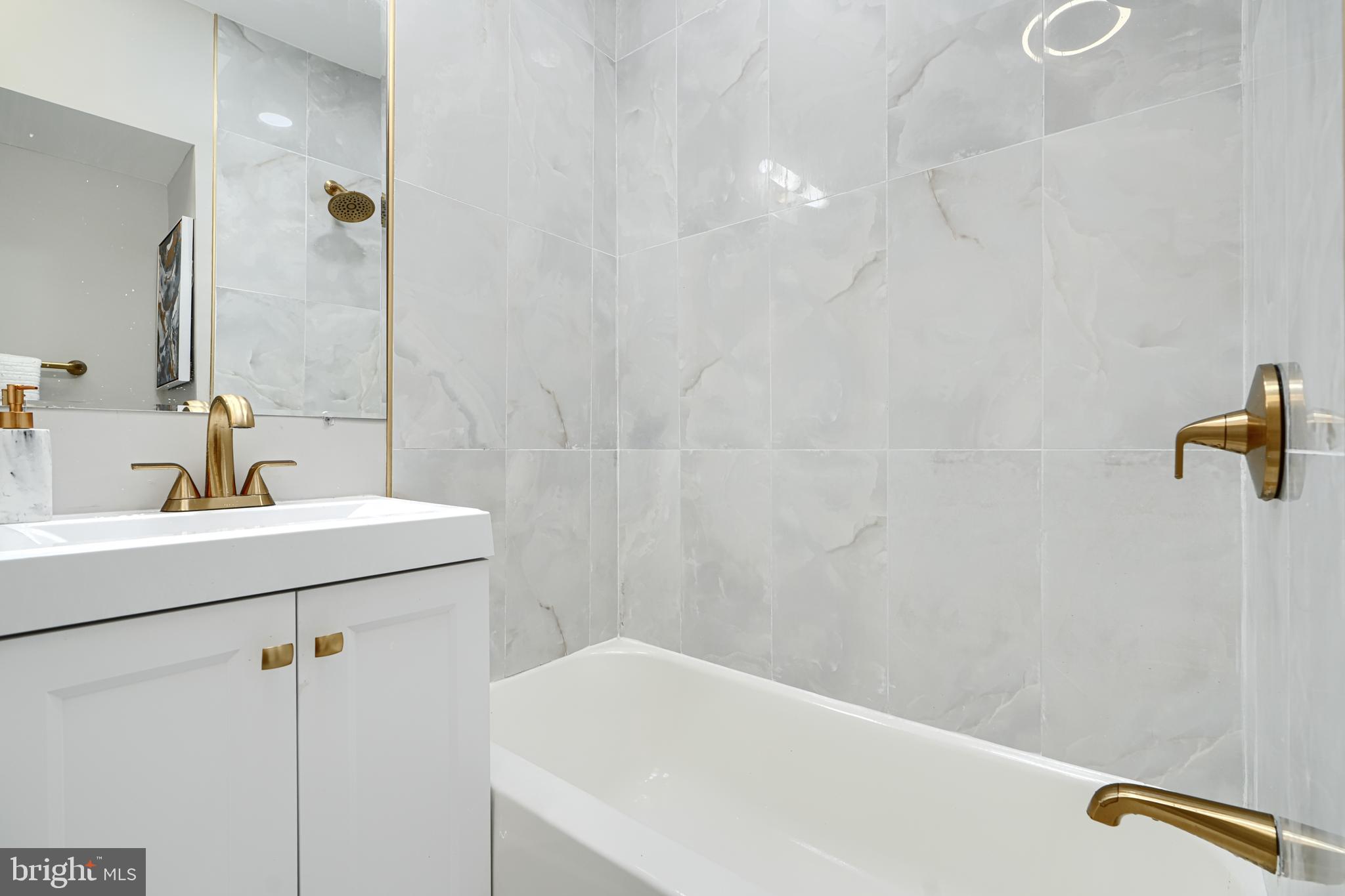 4004 Fairfax Road Baltimore, MD 21216 - Photo 14 of 23 a bathroom with a sink a tub and a mirror