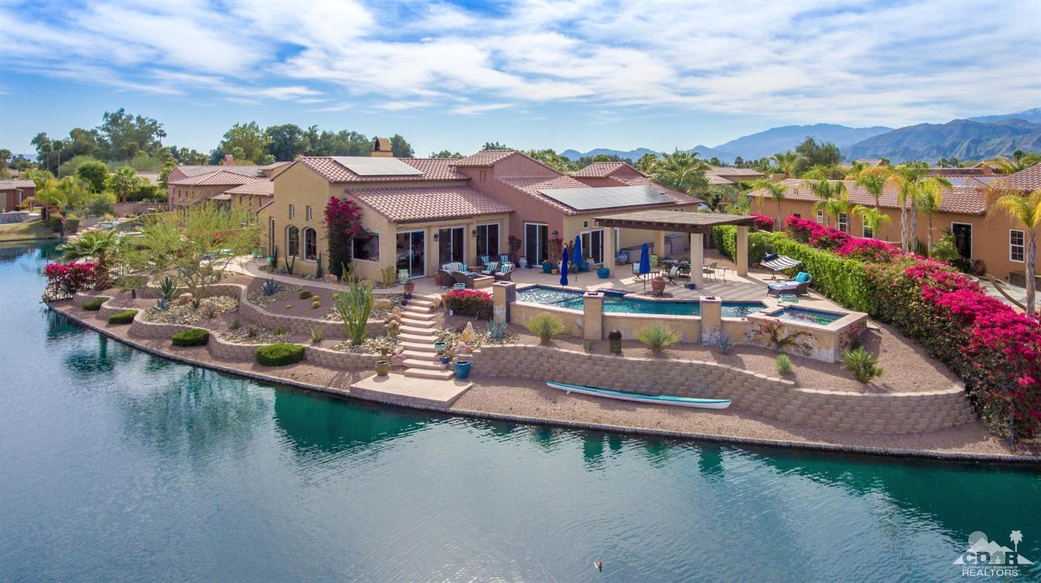 10 Via Santa Ramona Rancho Mirage, CA 92270 - Photo 6 of 78 a front view of a house with a garden and lake view