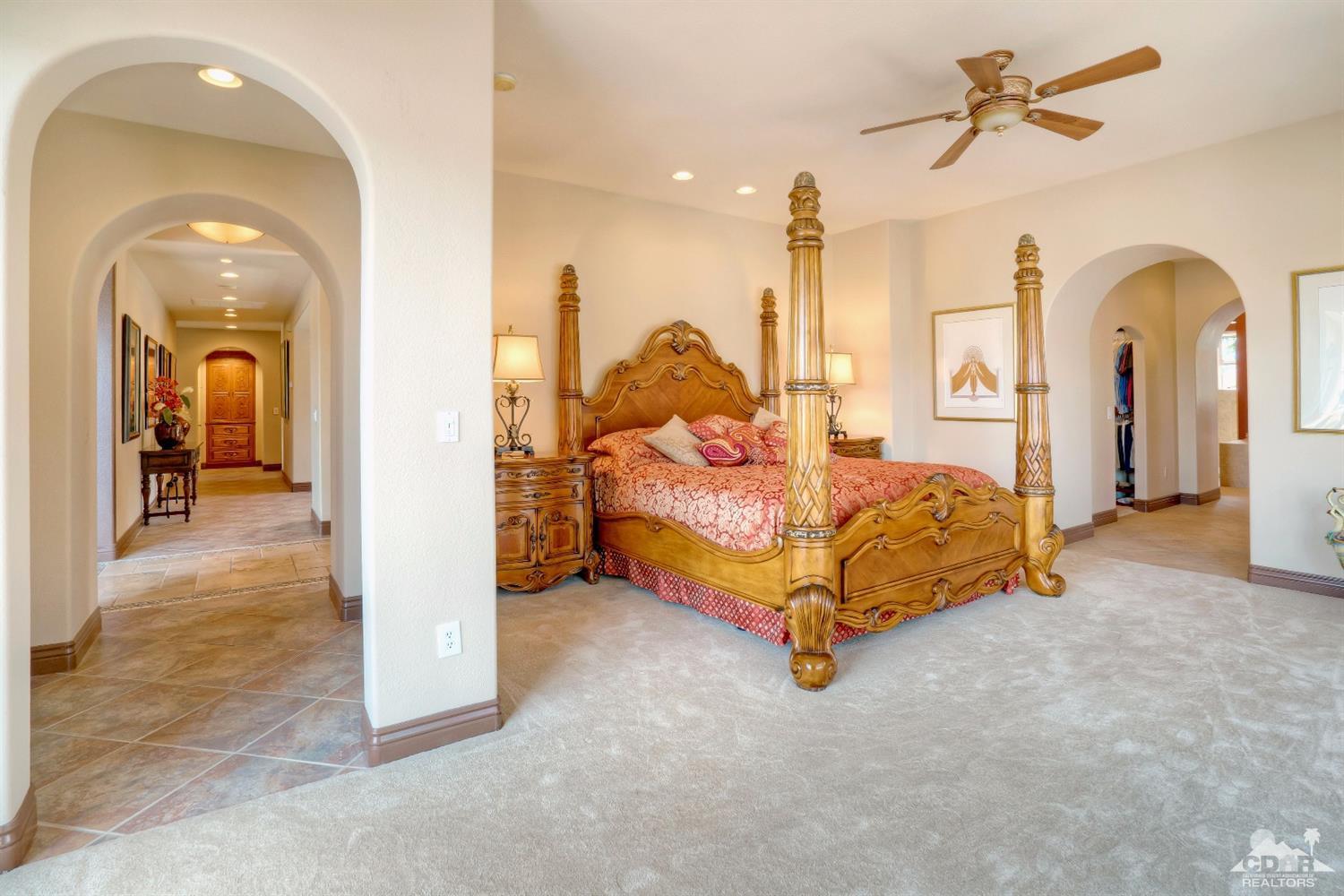10 Via Santa Ramona Rancho Mirage, CA 92270 - Photo 65 of 78 a spacious bedroom with bed and a chandelier