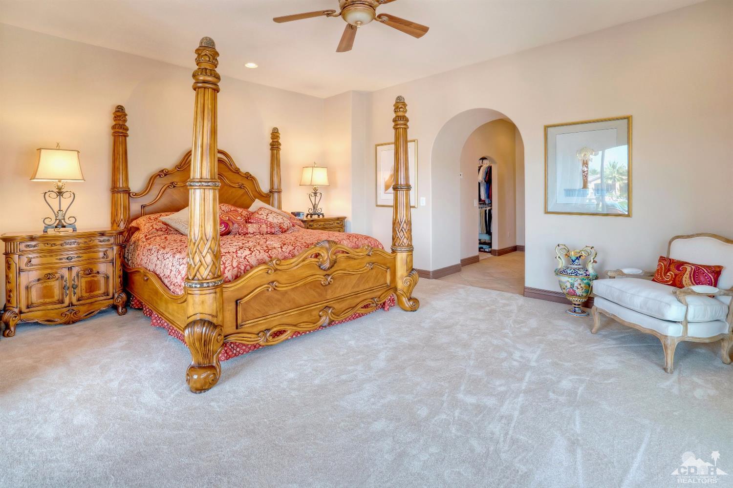 10 Via Santa Ramona Rancho Mirage, CA 92270 - Photo 66 of 78 a spacious bedroom with a bed and a chandelier