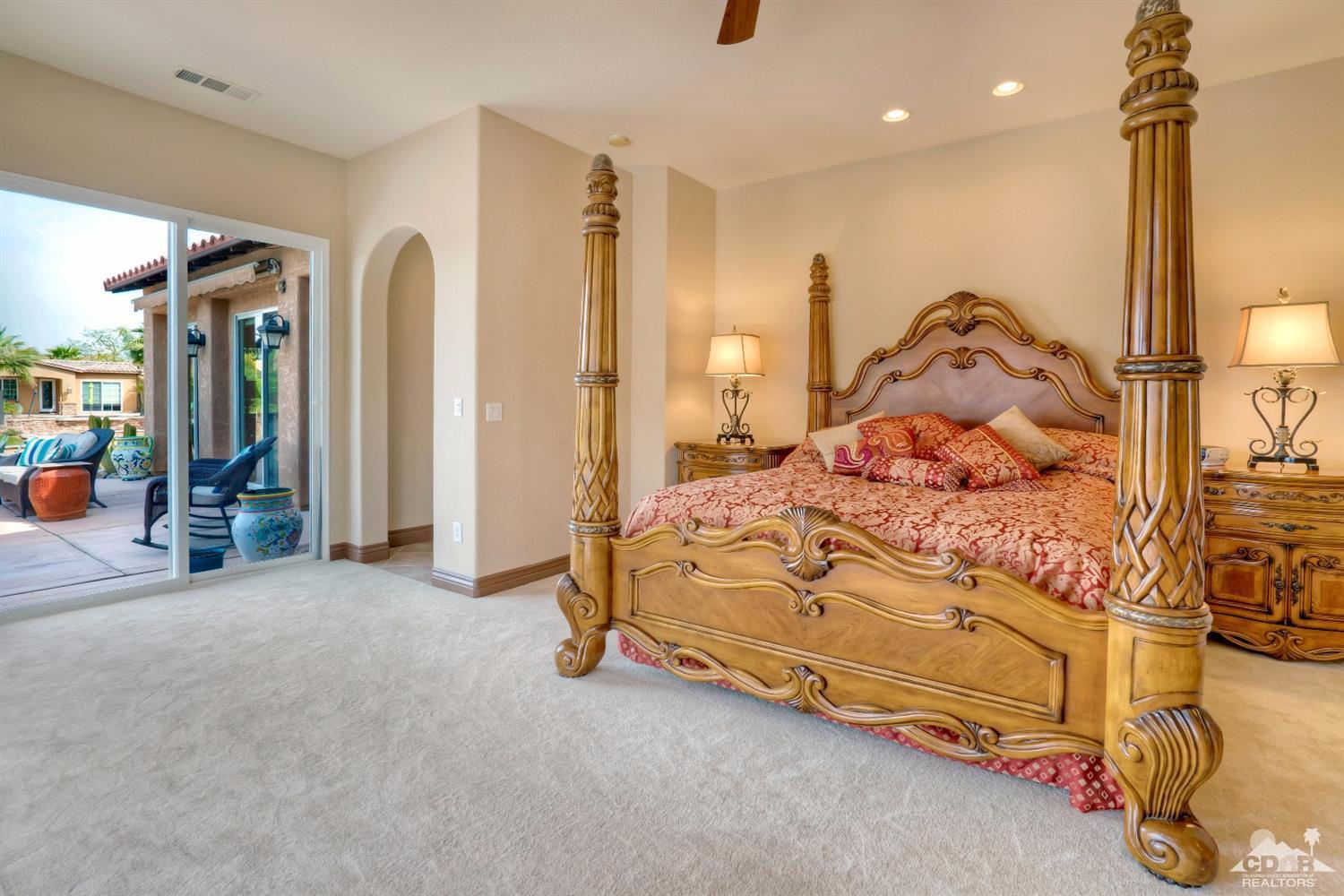 10 Via Santa Ramona Rancho Mirage, CA 92270 - Photo 67 of 78 a spacious bedroom with a bed and a chandelier