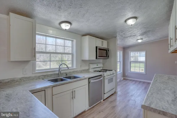an empty room with wooden floor and cabinets