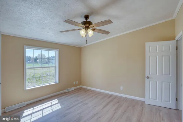an empty room with wooden floor a ceiling fan and closet