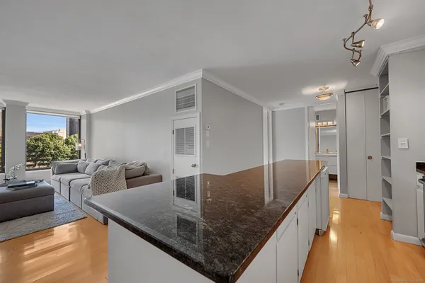 a living room with furniture and view of kitchen