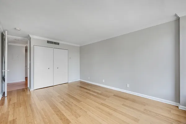 a view of an empty room with wooden floor