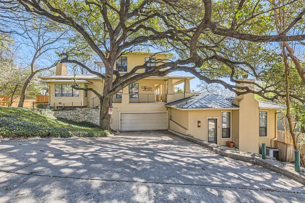 a view of a house with a large tree and a yard