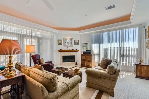 a living room with furniture a fireplace and a large window