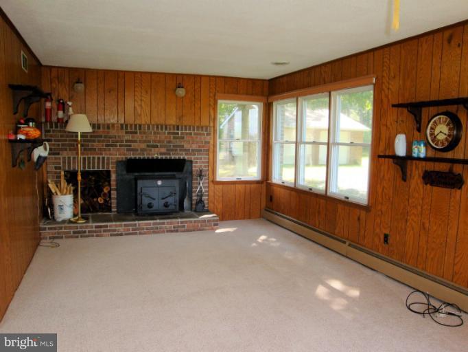 16236 Pine Tree Lane Ridge, MD 20680 - Photo 14 of 30 a view of an empty room with a fireplace and a window