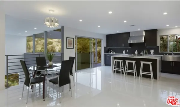 a dining area with stainless steel appliances kitchen island granite countertop a dining table chairs and stove