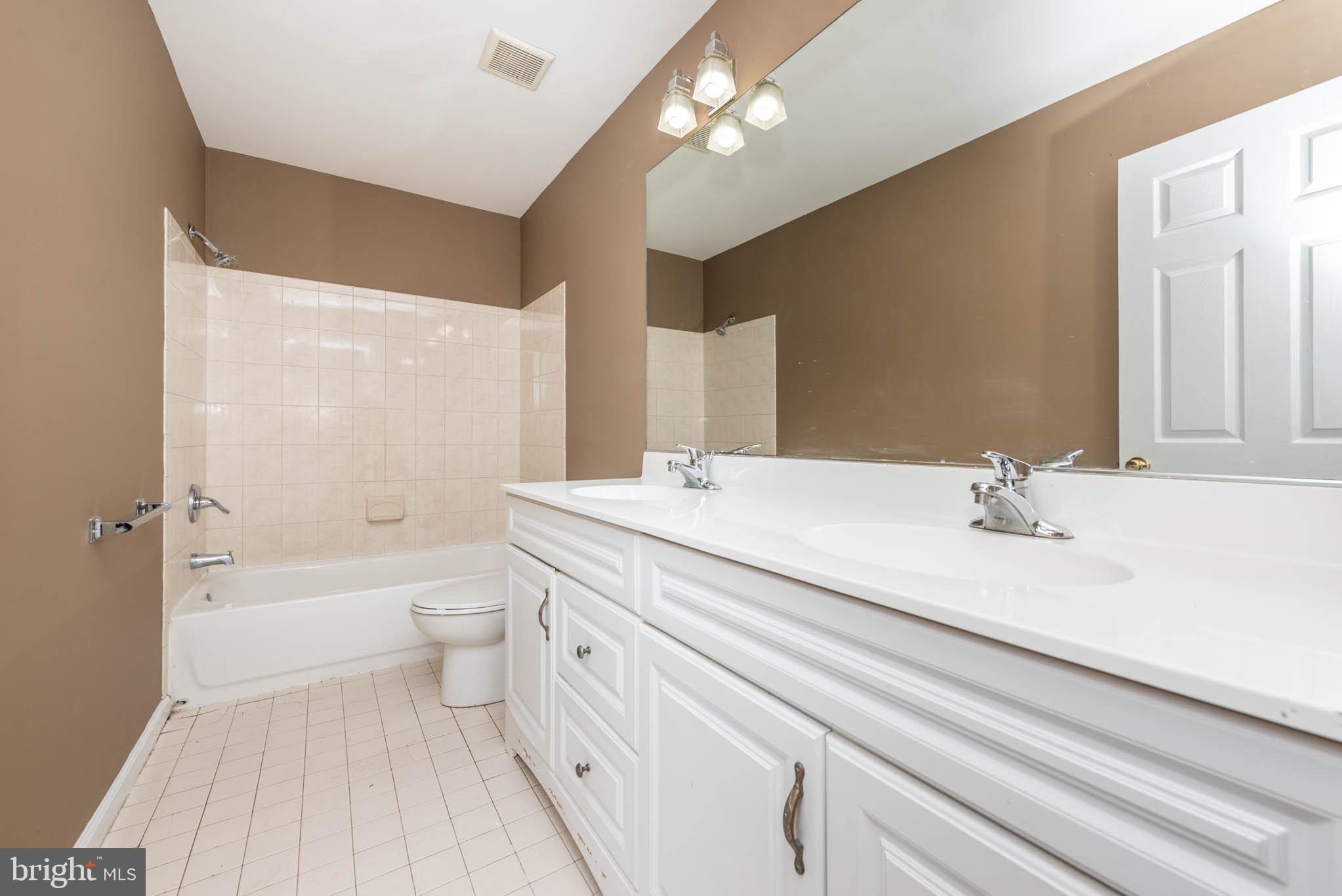 4021 Barrington Road Baltimore, MD 21207 - Photo 18 of 50 a bathroom with a bathtub a sink and a large mirror