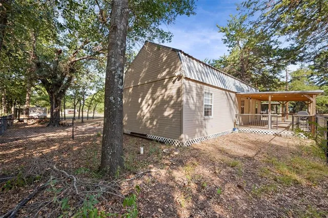 a view of a house with backyard and trees