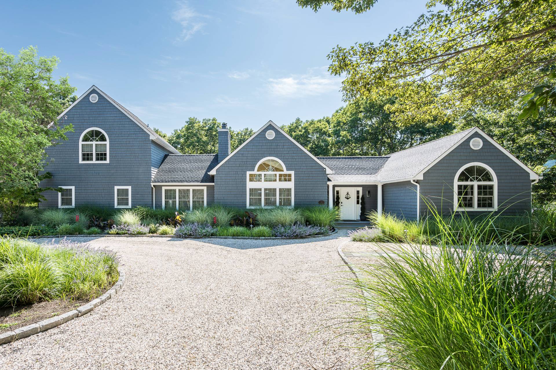14 High Ridge Road East Hampton, NY 11937 - Photo 13 of 43 a front view of a house with a yard and potted plants