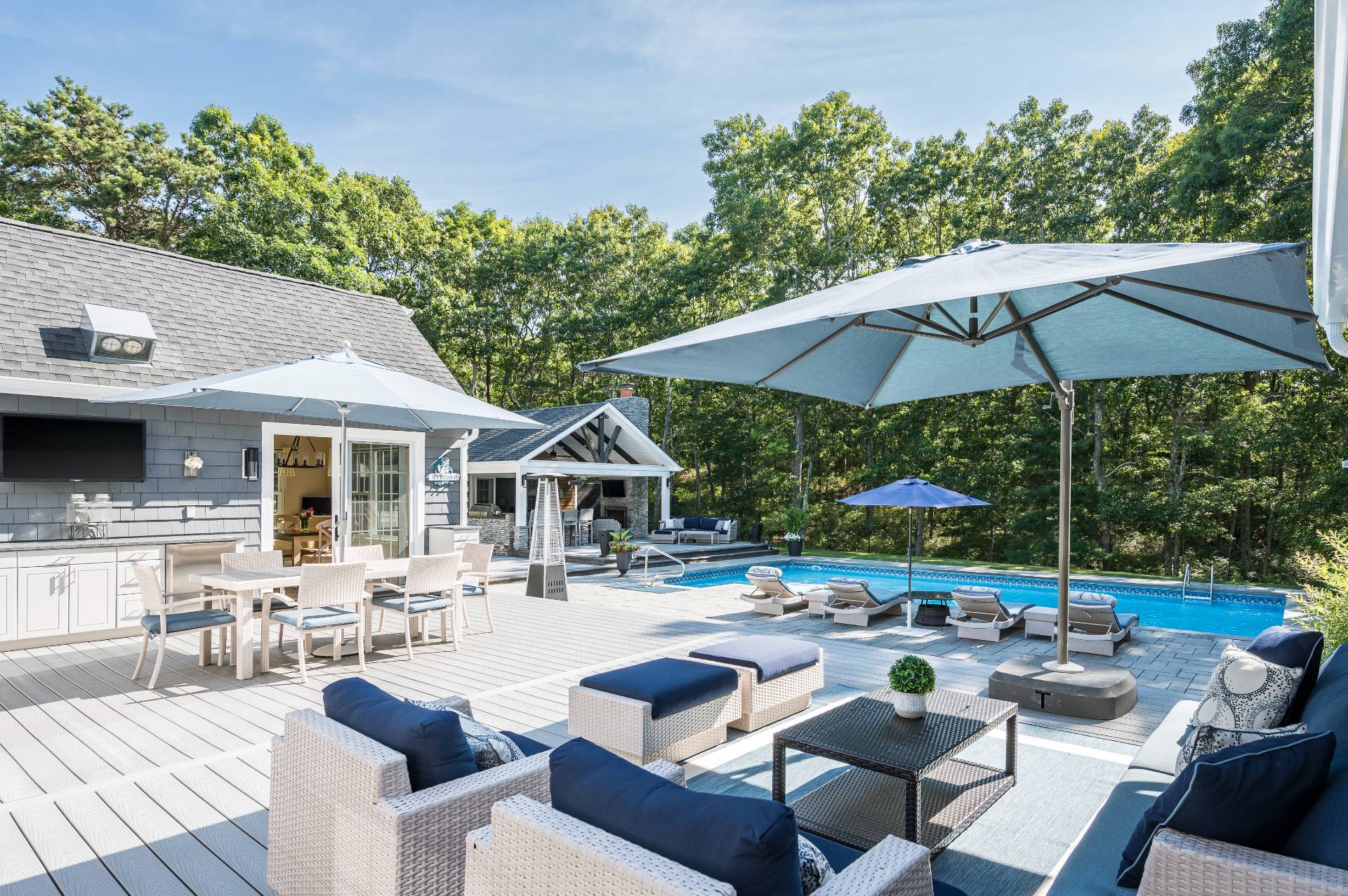 14 High Ridge Road East Hampton, NY 11937 - Photo 10 of 43 a view of a patio with chairs and a table and chairs under an umbrella