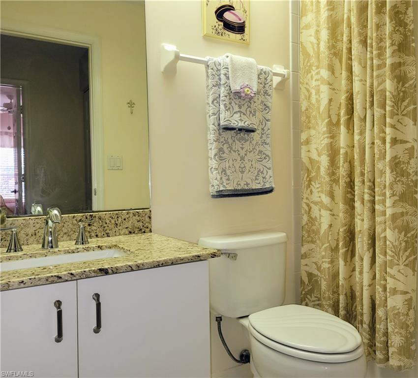 7435 Plumbago Bridge Road, Unit K201 Naples, FL 34109 - Photo 15 of 17 a bathroom with a granite countertop sink and a mirror