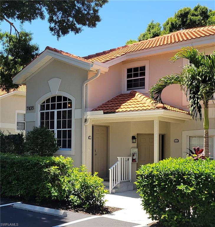 7435 Plumbago Bridge Road, Unit K201 Naples, FL 34109 - Photo 2 of 17 front view of a house with a yard