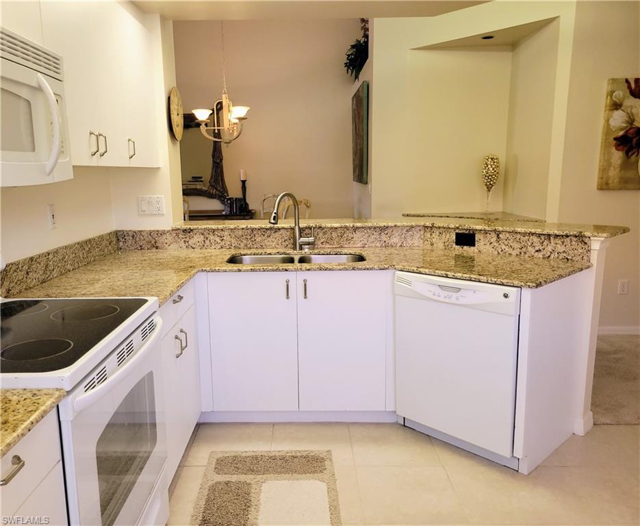 7435 Plumbago Bridge Road, Unit K201 Naples, FL 34109 - Photo 5 of 17 a kitchen with a sink stove and cabinets