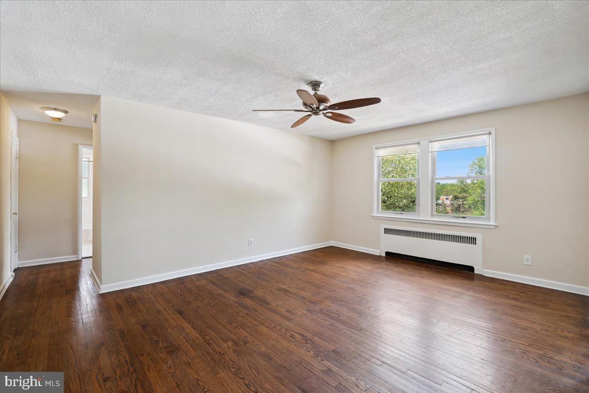 4029 Benton Street Northwest, Unit 302 Washington, DC 20007 - Photo 2 of 27 an empty room with wooden floor and windows