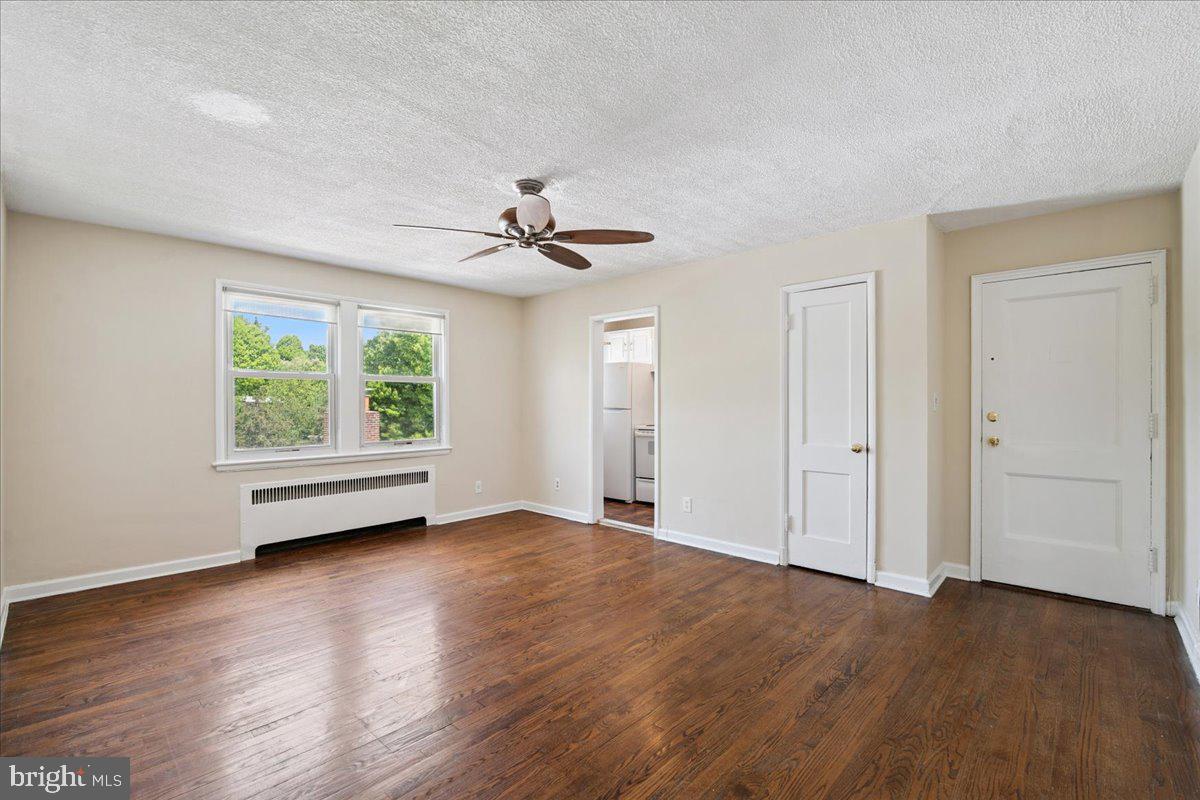 4029 Benton Street Northwest, Unit 302 Washington, DC 20007 - Photo 4 of 27 a view of an empty room with wooden floor and a window