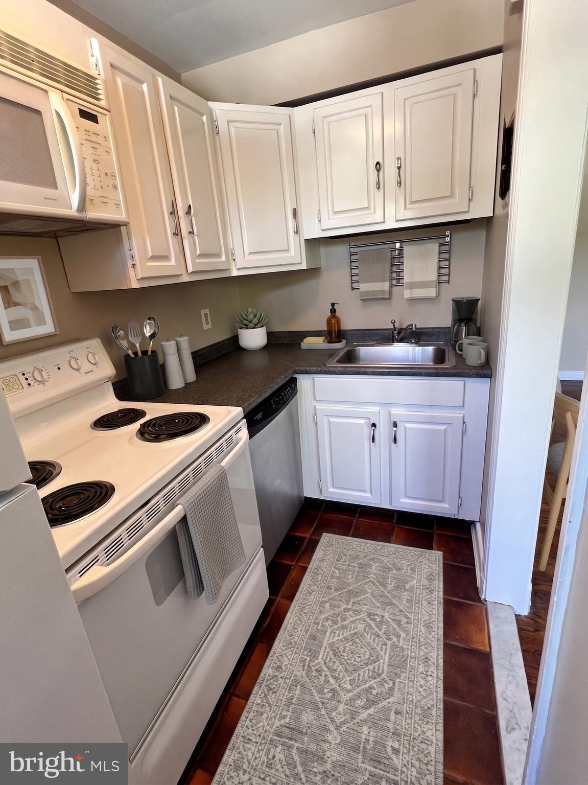 4029 Benton Street Northwest, Unit 302 Washington, DC 20007 - Photo 5 of 27 a kitchen with granite countertop a sink a stove and cabinets
