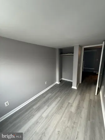 an empty room with wooden floor and closet