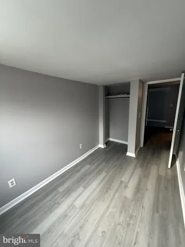an empty room with wooden floor and closet