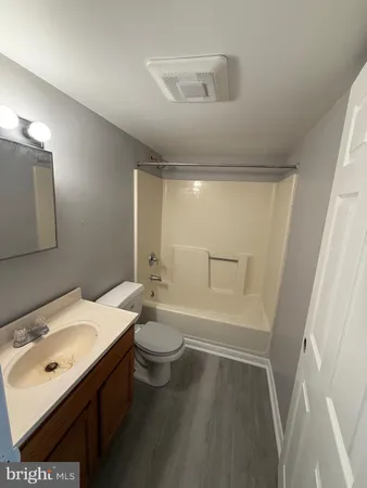 a bathroom with a sink a toilet a mirror and shower