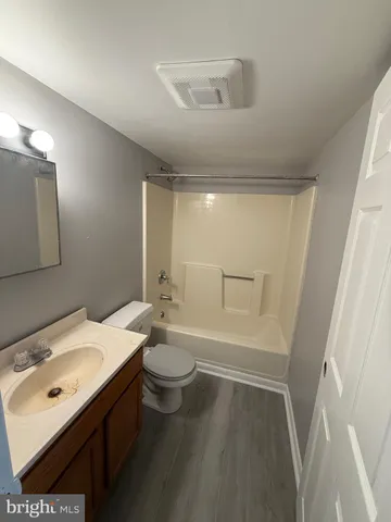 a bathroom with a sink a toilet a mirror and shower