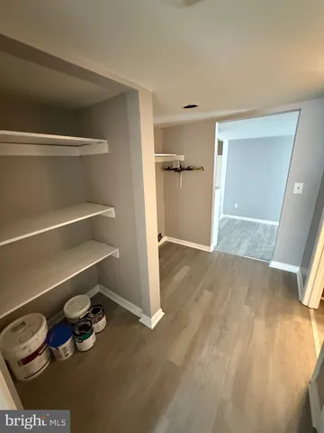 a view of empty room with wooden floor and bathroom