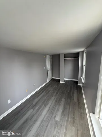 an empty room with wooden floor and closet
