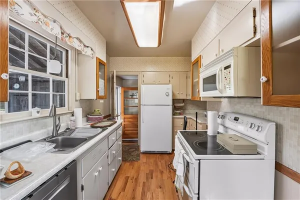 a kitchen filled a sink a refrigerator and window