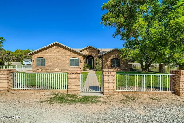 a view of a house with a small yard and wooden fence