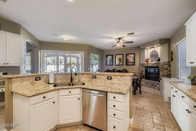 a kitchen with granite countertop a sink stove and cabinets