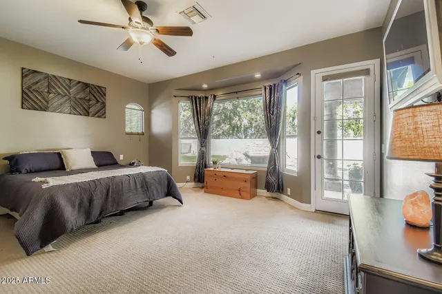 a spacious bedroom with a bed and glass door