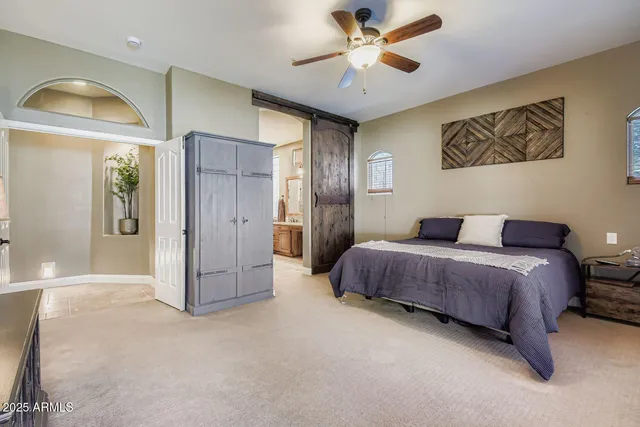 a spacious bedroom with a bed and a chandelier