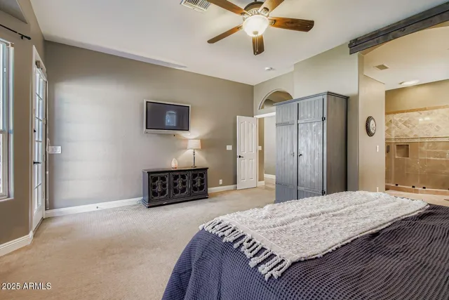 a spacious bedroom with a bed and a chandelier