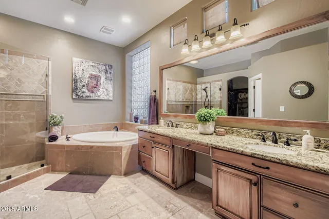 a spacious bathroom with a granite countertop sink mirror and bathtub