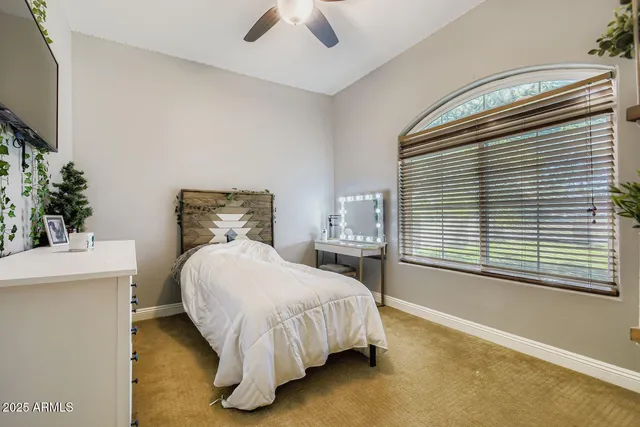 a bed sitting in a bedroom next to a window