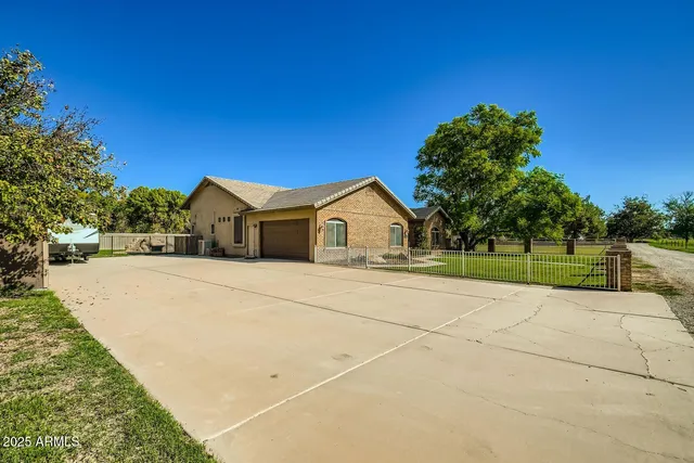 a front view of a house with a yard and trees