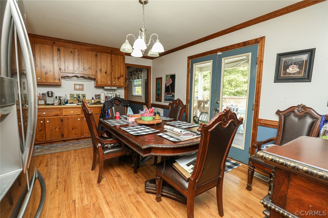 13120 Hensley Road Midlothian, VA 23112 - Photo 10 of 50 a view of a dining room with furniture a chandelier and wooden floor