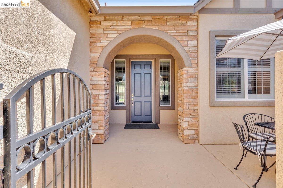 158 Rock Ridge Lane Copperopolis, CA 95228 - Photo 7 of 72 Stone veneer arched entryway featuring a grey paneled door and sidelight windows
