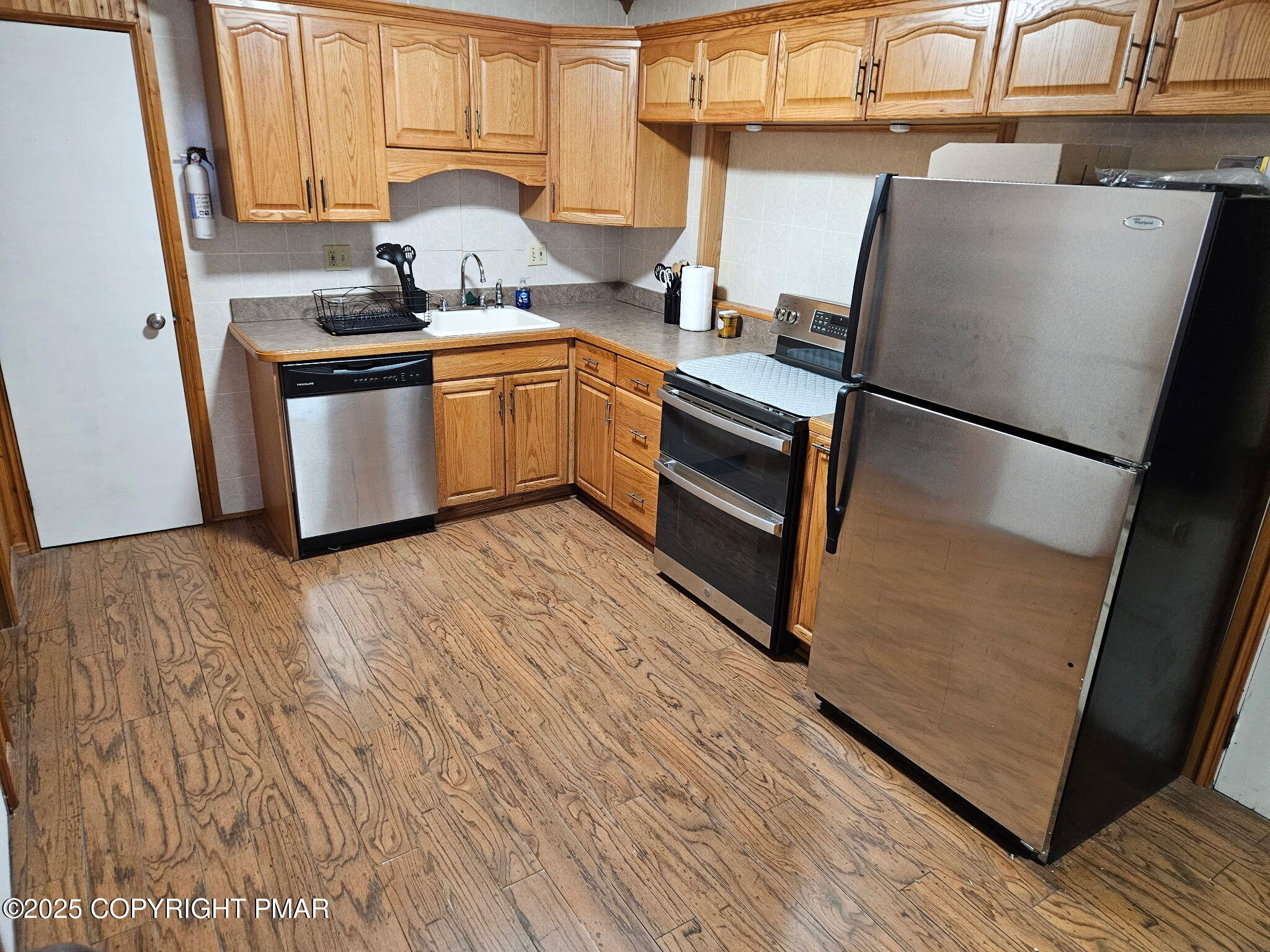 222 Nadine Boulevard Pocono Summit, PA 18346 - Photo 2 of 16 a kitchen with stainless steel appliances a refrigerator sink and wooden floor