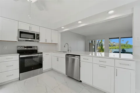 a kitchen with white cabinets and appliances