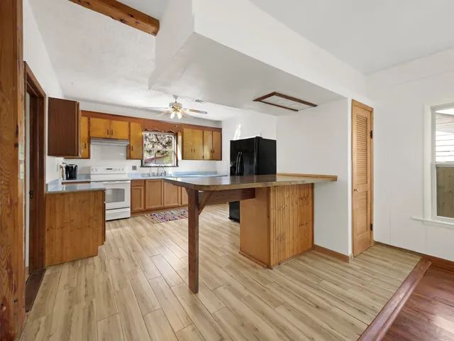 a kitchen with stainless steel appliances granite countertop wooden floors and view living room