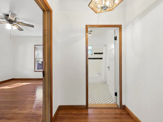 a view of a hallway with wooden floor and closet