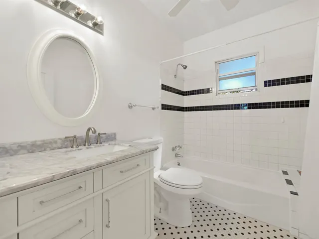 a bathroom with a granite countertop sink a toilet and a bathtub