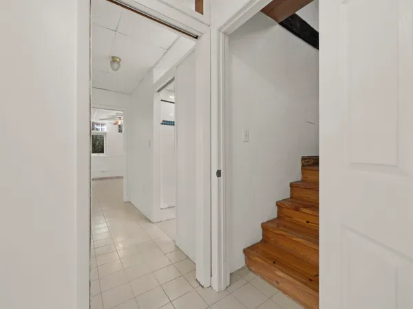 a view of a hallway with staircase and white walls